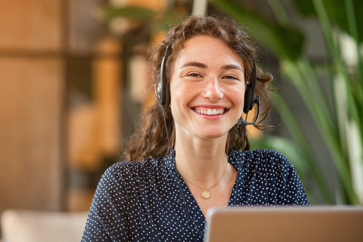 Lachende klantenservicemedewerker met headset die klanten ondersteunt met Astro Go WMS