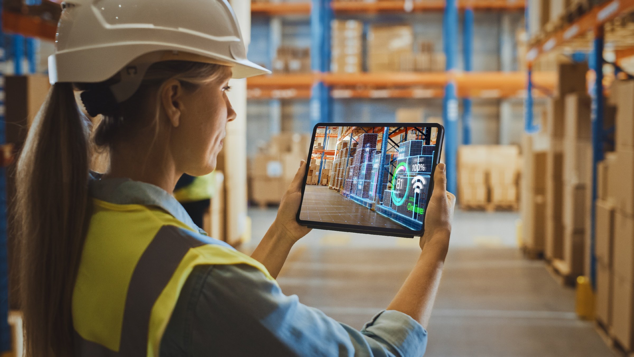 Vrouw gebruikt digital twin supply chain warehouse reality-applicatie op een tablet