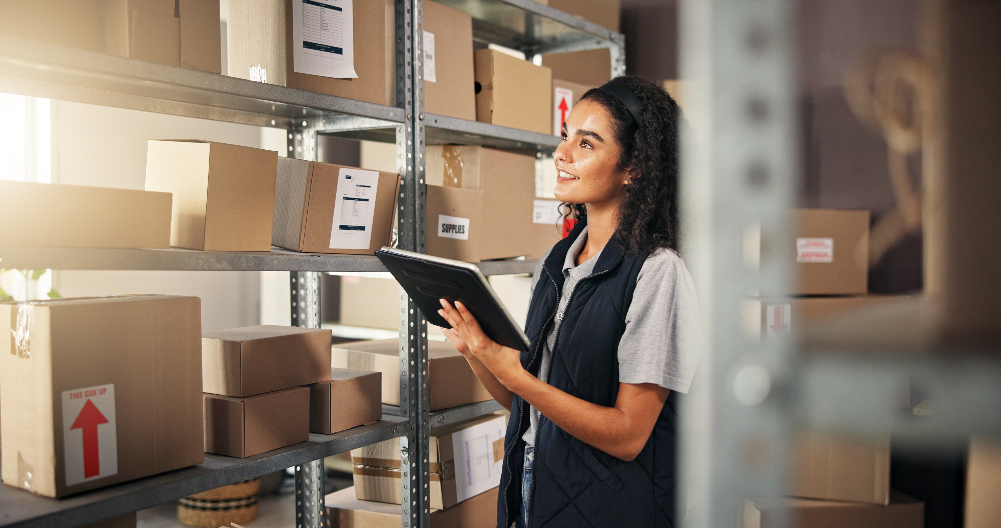 Warehouse Management for Small Business met een medewerker die een tablet gebruikt om de voorraad in de schappen te beheren.